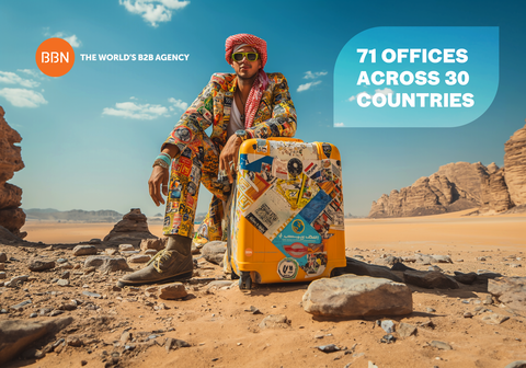 Zu sehen ist ein junger Mann mit Turban und Sonnenbrille, der mit seinem Reisekoffer mitten in der Wüste sitzt. Seine Anzug und sein Koffer sind vollgepackt mit Reiseaufklebern und Urlaubs-Badges. Auf dem Bild steht noch rechts neben dem Mann eine Blase mit dem Text „71 Offices across 30 countries“. Das Bild steht symbolisch für Reiseerfahrung und Weltgewandtheit.  | © wob AG