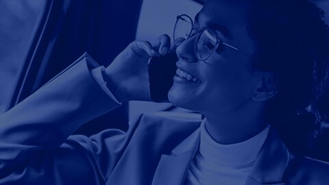Keyvisual Case Content Hub Finanzdienstleister | © wob AG Zu sehen ist im Anschnitt eine Frau mit Anzug und Brille, die gerade telefoniert und dabei zufrieden in die Ferne blickt. Über dem Bild ist ein Blaufilter platziert. | © wob AG