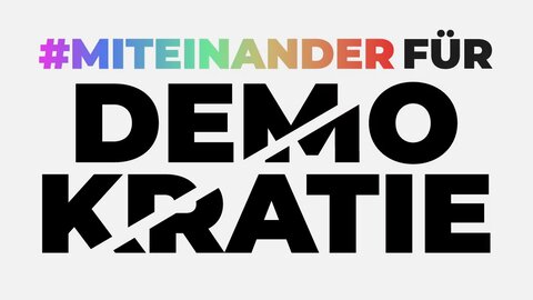 Initiative #MiteinanderfürDemokratie Auf dem Bild ist nur Typographie zu sehen. Zuoberst steht „#Miteinander“ in bunten Buchstaben. In schwarz folgt das Wort „für“. Darunter steht in noch größeren Buchstaben „Demokratie“. Durch das Wort verläuft ein heller Streifen, der aussieht, als würde er das Wort „Demokratie“ zerschneiden.